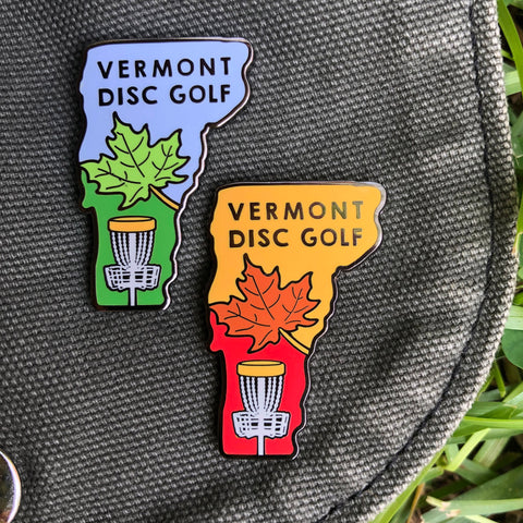 Vermont Disc Golf Pin on a disc golf bag in blue color way and orange color way