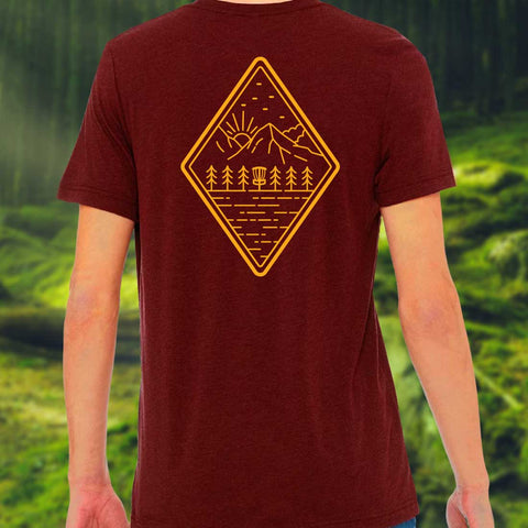 dark red shirt with a simple diagonal forest landscape and disc golf basket